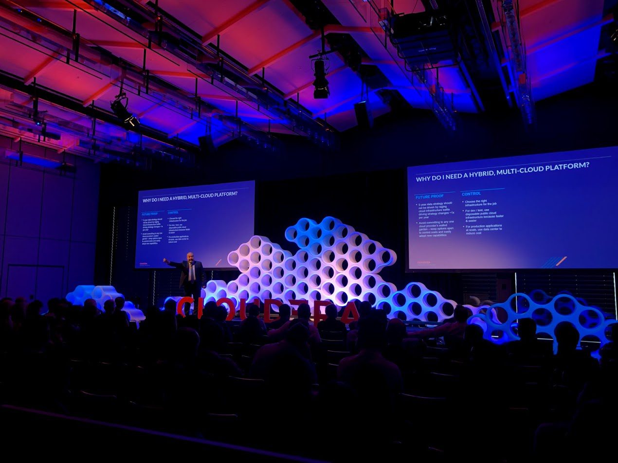 Conference stage with coordinated screens, lighting and sculptural event backdrop