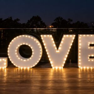 White LOVE letters with warm bulbs around their edges on an event deck