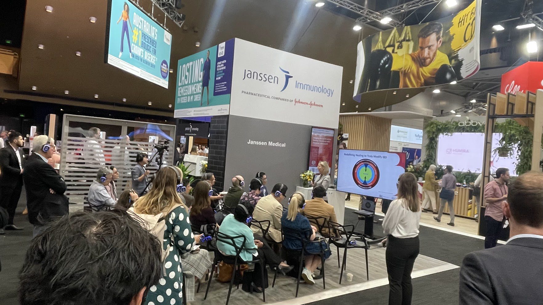 Exhibition presentation with display screen and wireless audience headphones