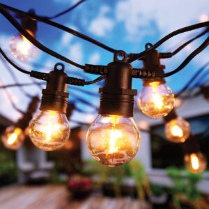 Outdoor String Lights with Warm Glowing Bulbs Above a Blurred Patio Scene at Dusk/evening Groove.