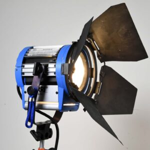 Blue Studio Spotlight with Metal Barn Doors and a Mounted Stand, Used for Directional Lighting in Photography or Film.