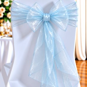 White chair covered in white fabric with a large pale blue sheer ribbon bow, typical of wedding decor.