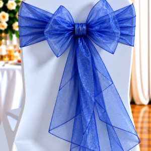 Decorated chair with a white cover and a large blue sheer sash tied in a bow at the back.