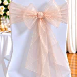 White chair covered in fabric with a large sheer blush-pink bow tied at the back, decor for a wedding.