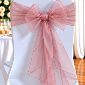 Organza Dusty Pink | Osmic Productions White Chair Decorated with a Large Pale Pink Organza Bow, Typical of Wedding Reception Decor.