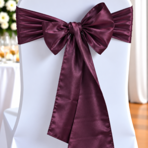 White banquet chair tied with a burgundy satin bow for a formal event.