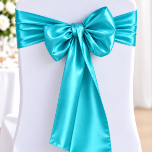 White banquet chair covered in a white fabric with a turquoise satin ribbon tied in a large bow at the back, as decor for a formal event.