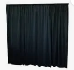 Closed black theater curtain hanging on a stage, covering the backdrop
