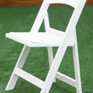 White folding chair set up on a green lawn or turf outdoor surface.