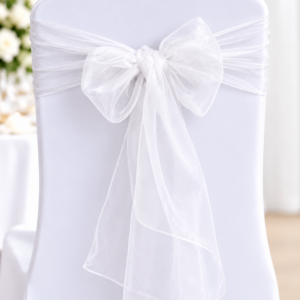 White chair covered in a satin cover with a large sheer bow tied at the back center outline of the chair